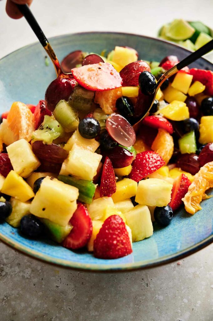 A bowl of fruit salad with a fork in it is a refreshing and healthy option for a snack or dessert.