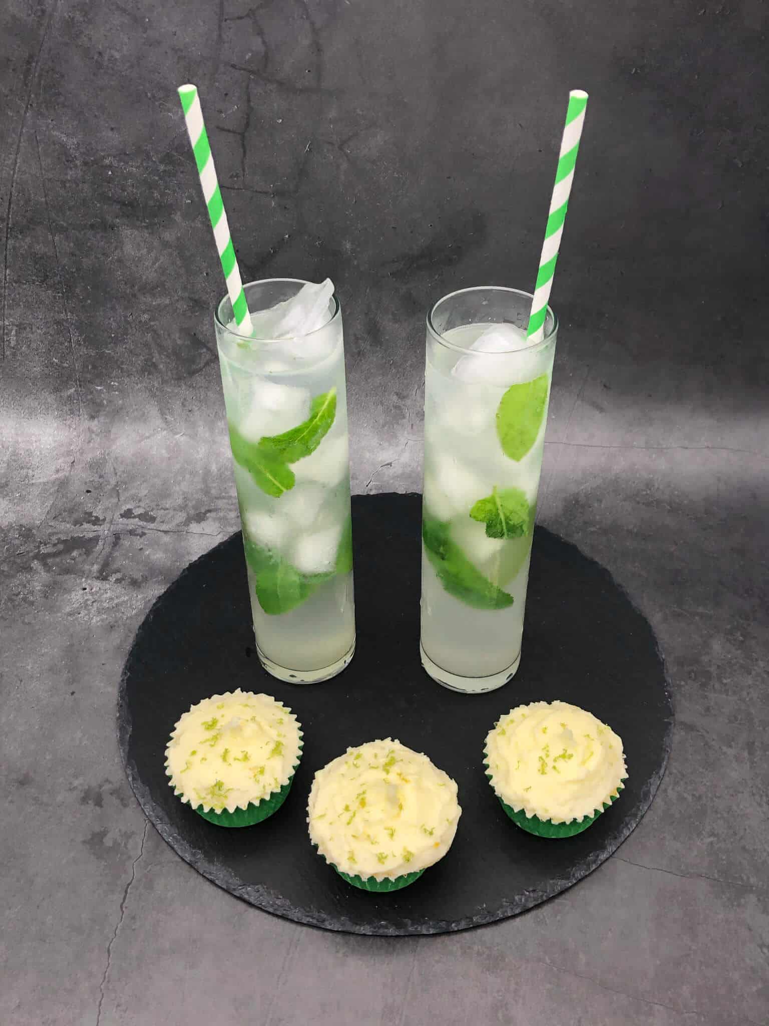 Three mojito cupcakes with two mojito cocktails