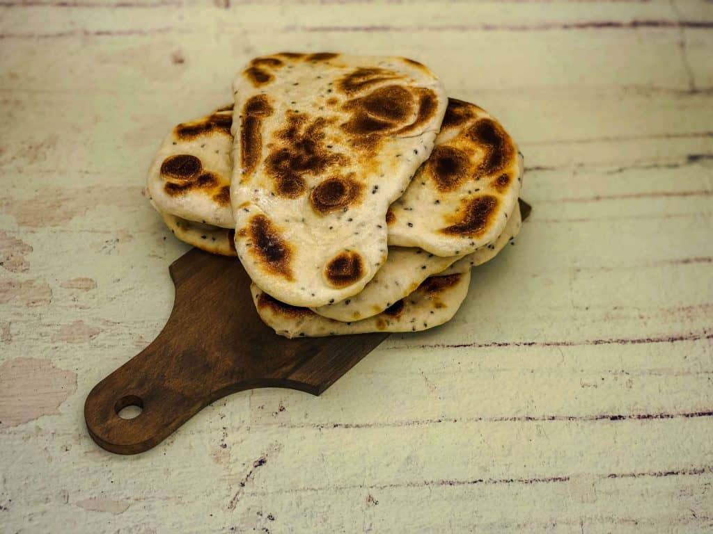 Homemade Indian Naan bread on a wooden serving board