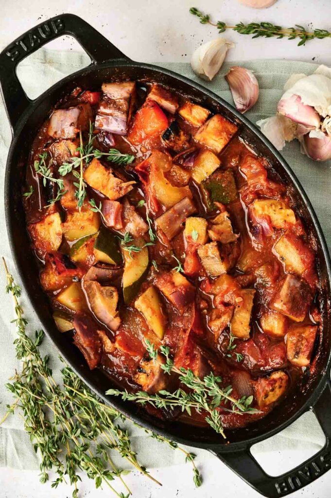 A flavorful ratatouille recipe cooked in a cast iron skillet with a medley of vegetables and aromatic herbs.
