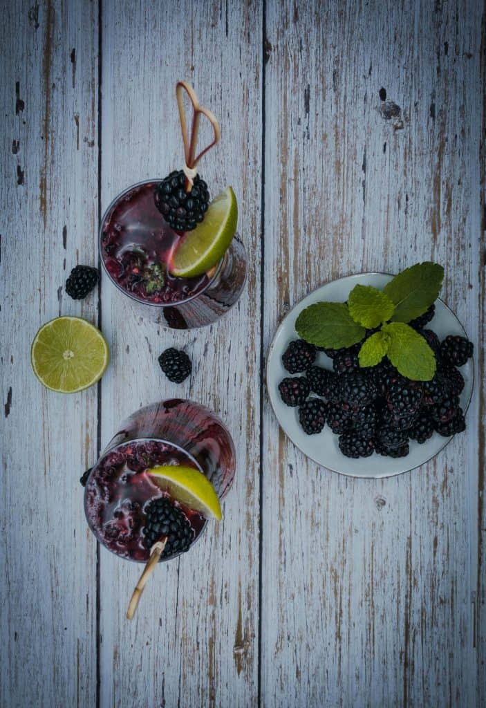 Blackberry cocktail with a plate of blackberries