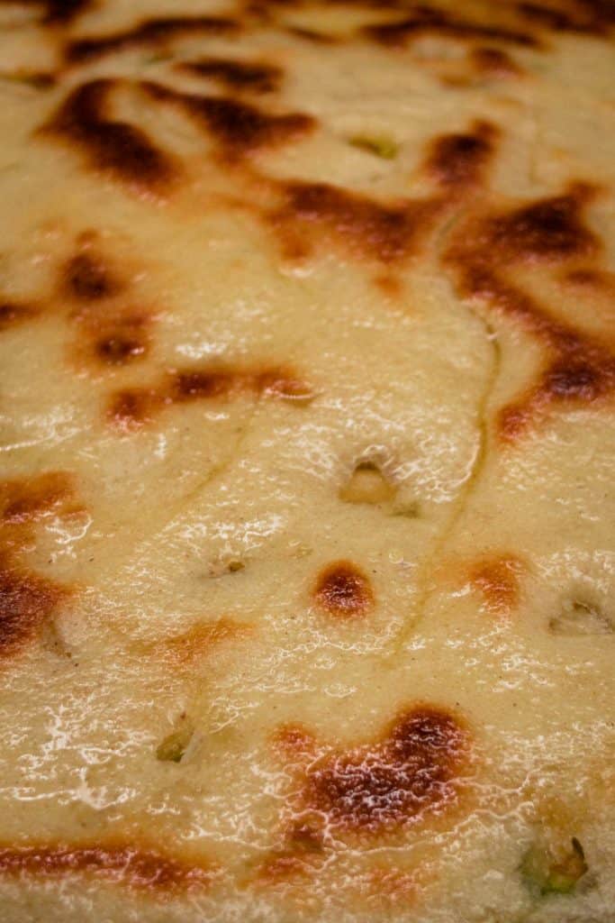 A close up of a hot Peshwari naan with melted butter over