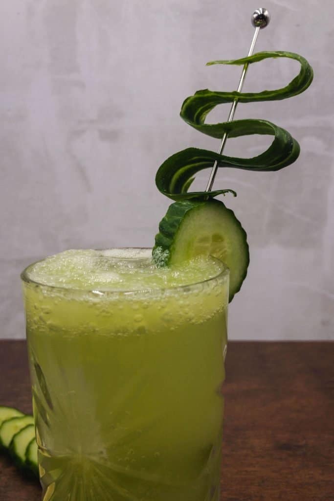 Tom Collins mocktail with ice and cucumber garnish