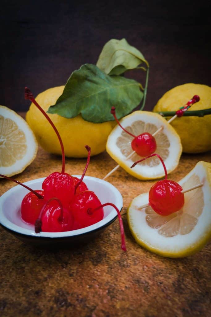 Maraschino cherries, slice of lemon and whole lemons