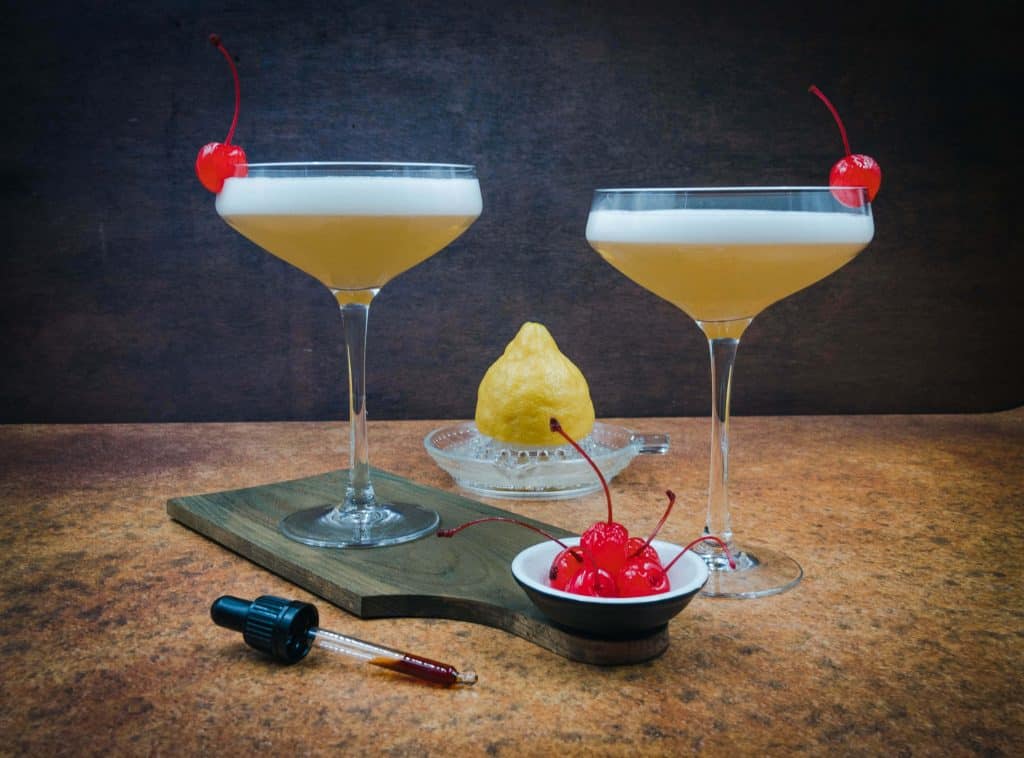 Amazing whiskey sour with frothy tops and Maraschino cherry garnish