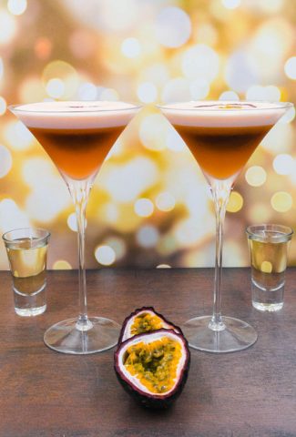Two stunning alcohol free pornstar martini cocktail drinks with fresh passion fruit and a shot of alcohol free champagne