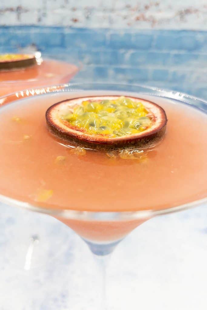 Close up of a homemade daiquiri drink passion fruit with a fresh half of passion fruit as garnish
