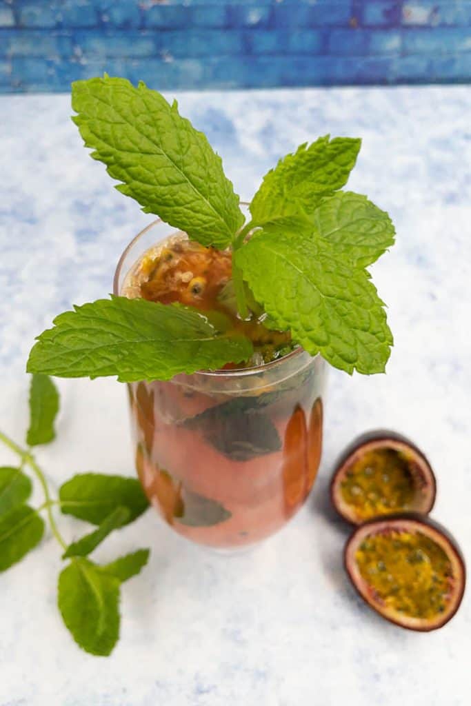 Homemade passion fruit mojito from above with mint leaves and passion fruit