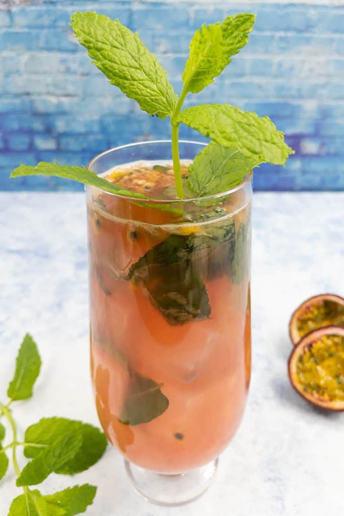 Homemade passion fruit mojito with fresh passion fruit and a green sprig of mint leaves