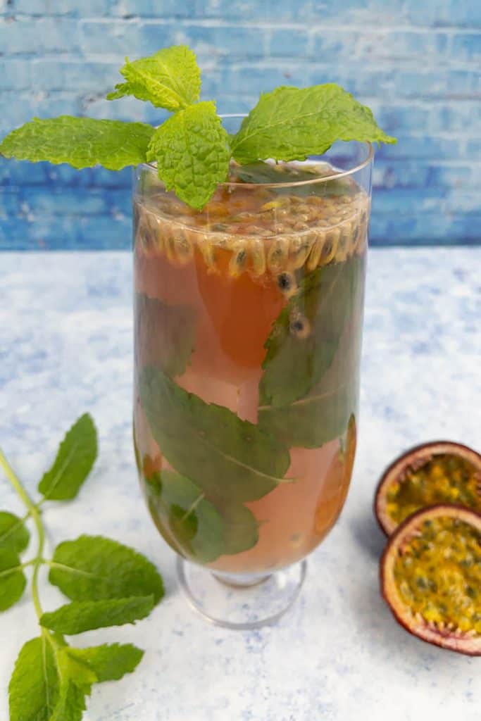 Close up of homemade passion fruit mojito in a glass with mint leaves, passion fruit