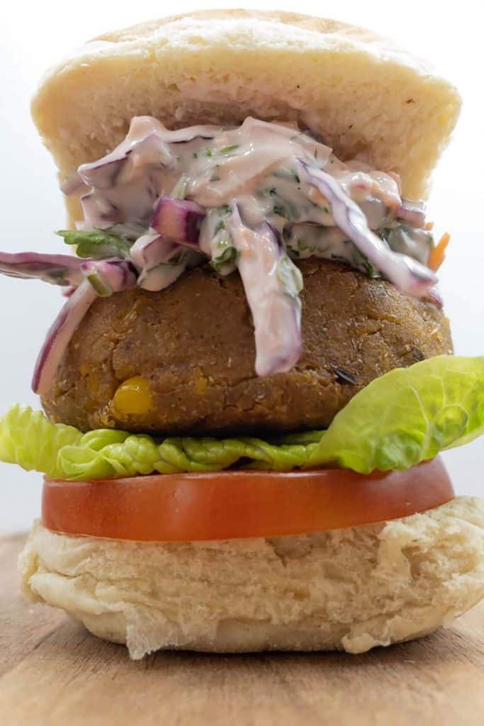 Tasty vegan chickpea burger with red cabbage slaw, lettuce and tomato ina burger bun