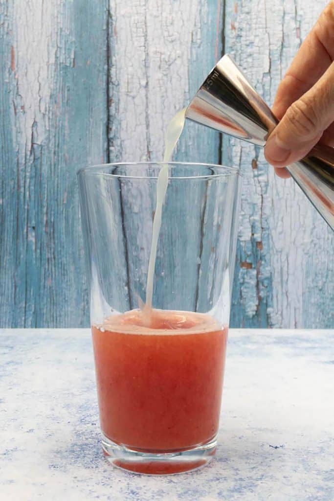 Add fresh lime juice to watermelon margarita cocktail.