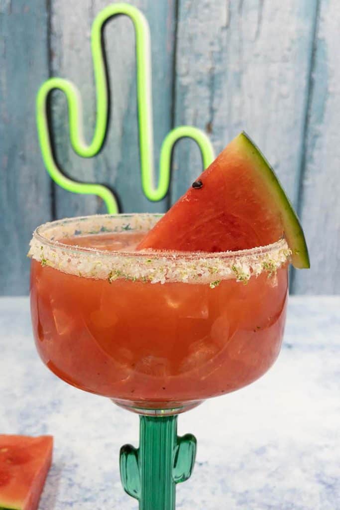 Perfect watermelon margarita cocktail made with tequila, with watermelon wedge garnish and neon cactus.