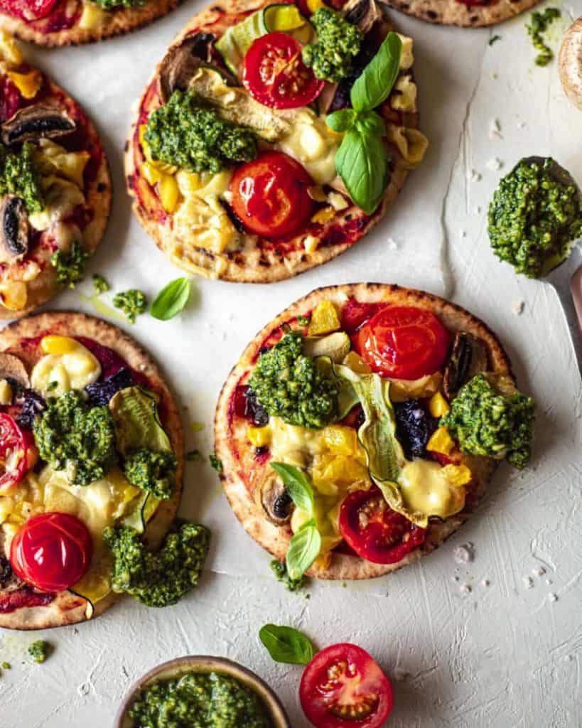 Easy vegan pita pizzas with pesto, cherry tomatoes and mushrooms.