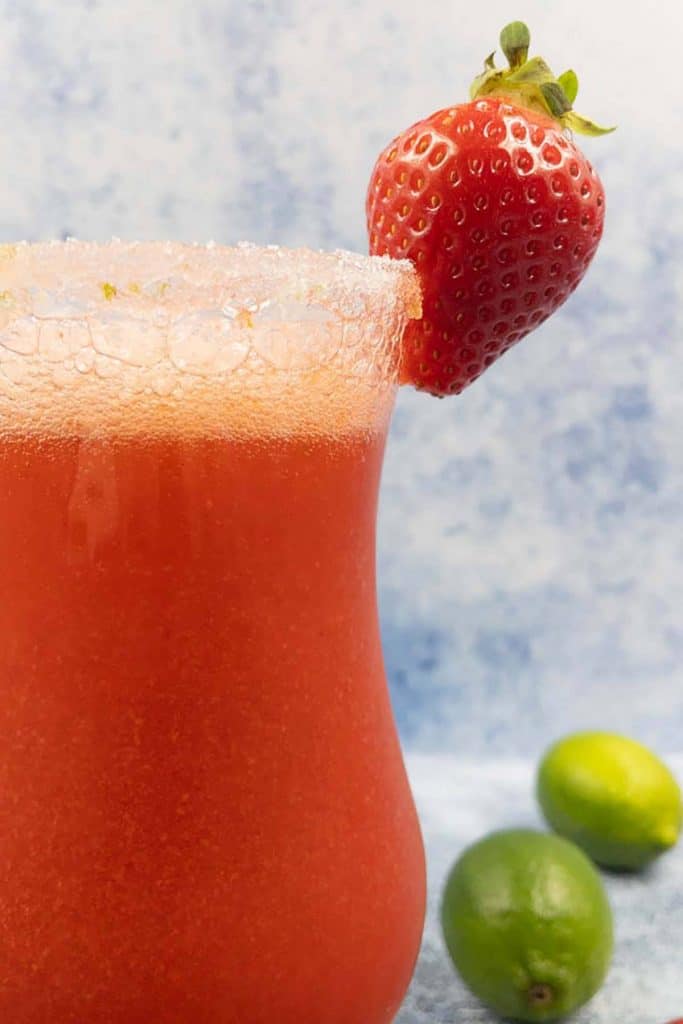 Close up of a virgn strawberry daiquiri drink with a sugar rim and strawberry garnish.