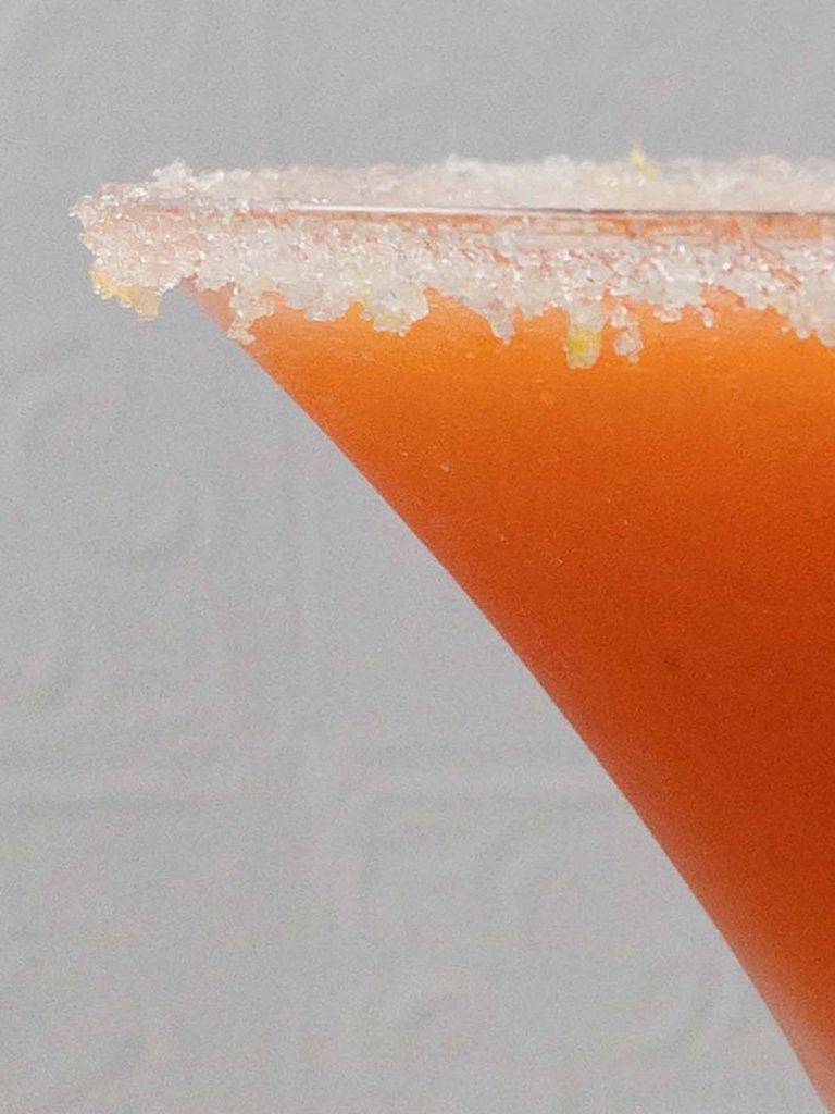 Close up of a sugared rim on a homemade strawberry martini in a martini glass.