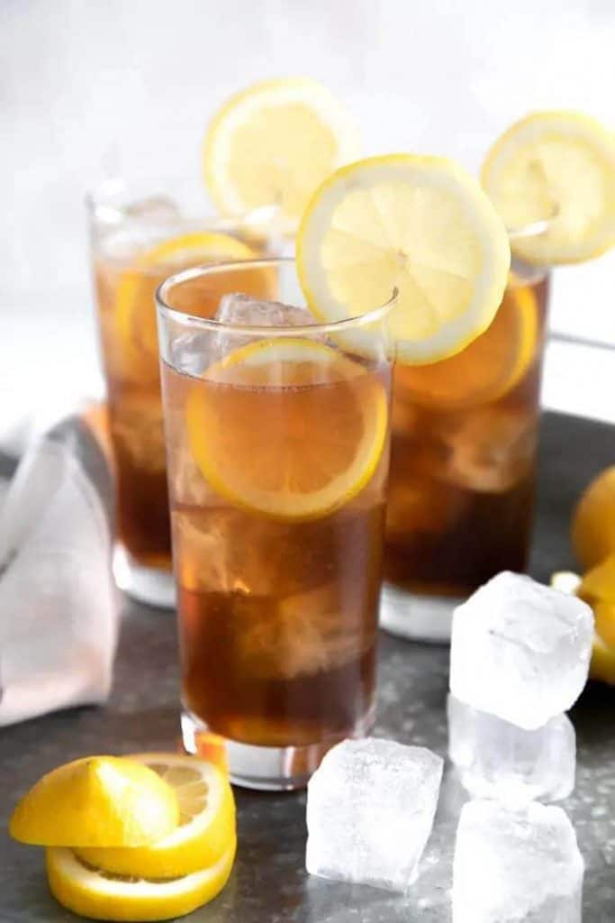 Long Island Ice Tea cocktails in cocktail glasses, with lemon wheels and ice cubes