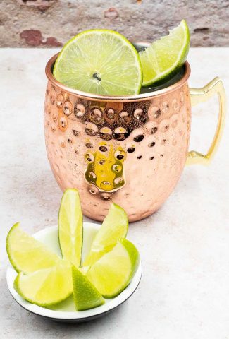Tasty Mexican Mule Cocktail Drink in a Copper Mug and Slice of lime and wedges.
