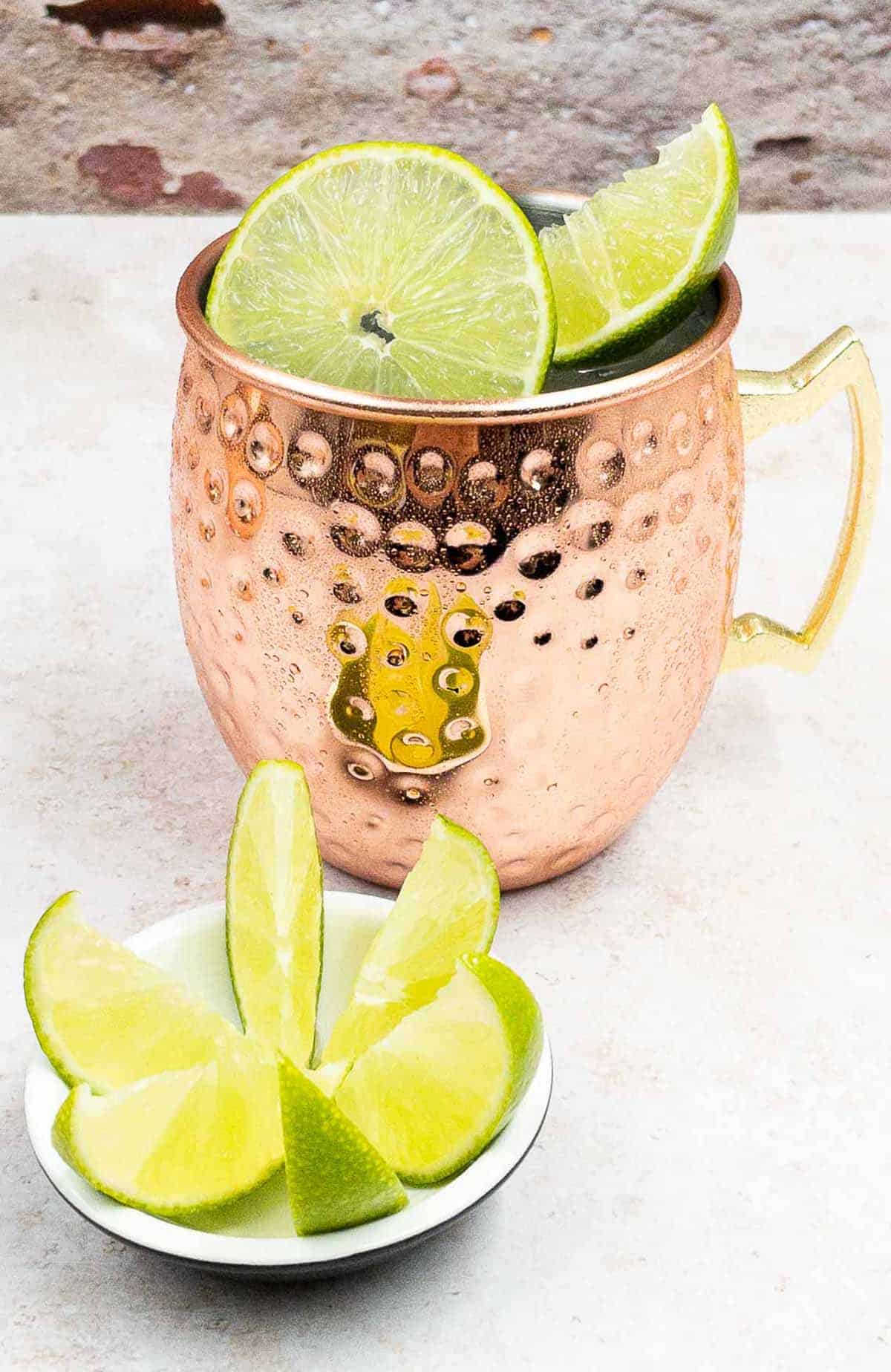 Tasty Mexican Mule Cocktail Drink in a Copper Mug and Slice of lime and wedges.