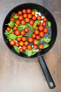 Cherry tomatoes with fresh basil and sliced garlic.