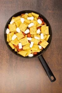 Process shot of paccheri pasta with fresh mozzarella and cherry tomatoes.