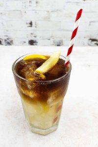 Homemade Long Island Iced Tea with tequila, gin, rum, vodka, triple sec, cola and lemon garnish with a straw.