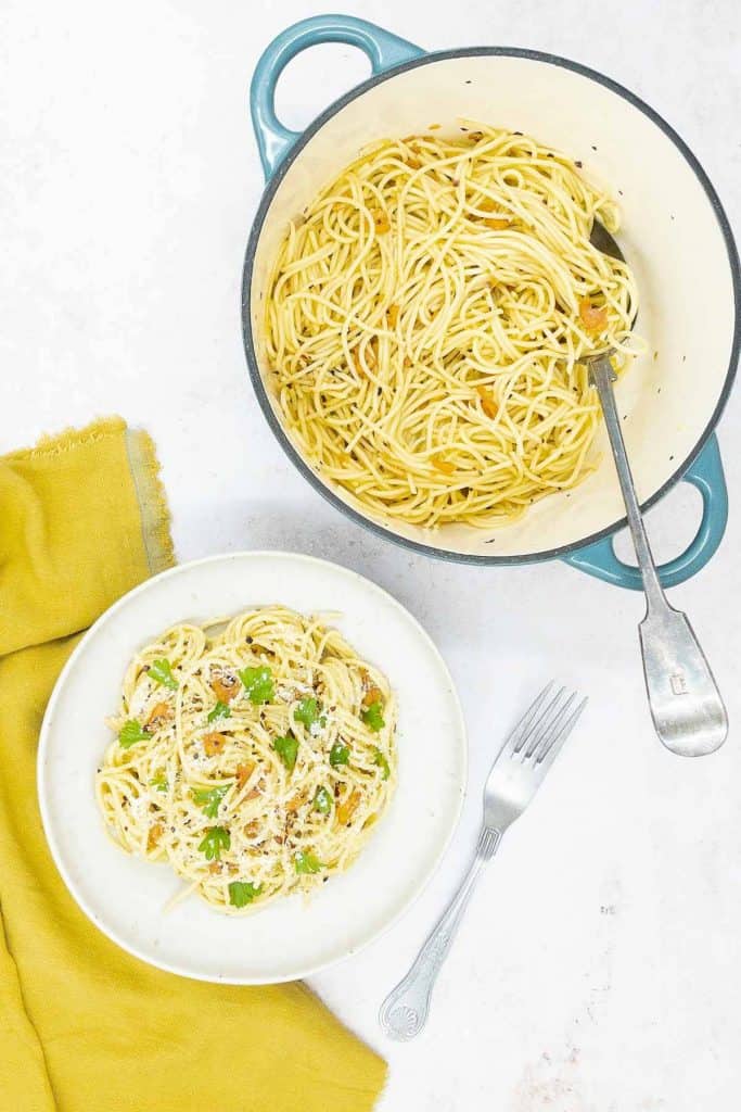 A pot full of freshly made spaghetti aglio e olio, garlic and olive oil, and a bowl full.