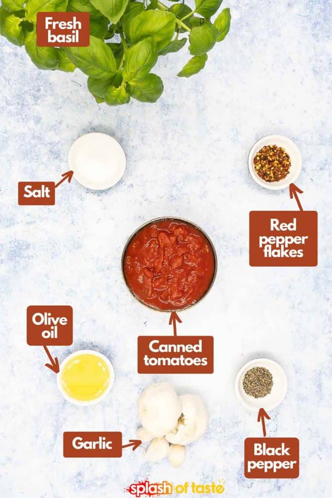 Ingredients for making arrabbiata sauce, fresh basil, salt, canned tomatoes, garlic, black pepper and red pepper flakes.