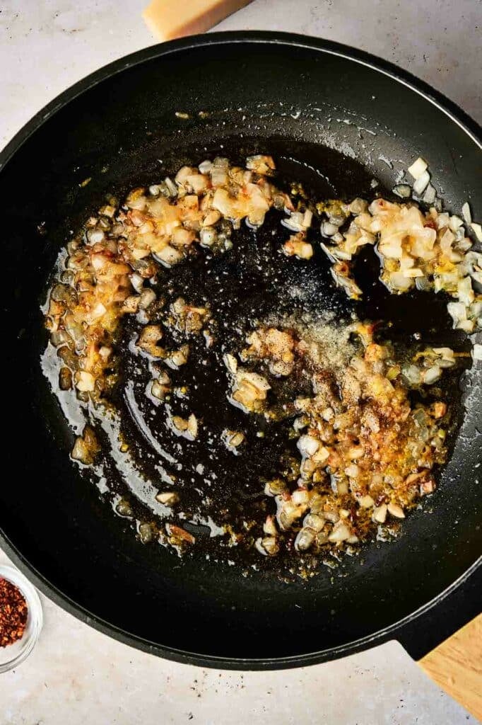 a pan with cooked onion, garlic, and lemon juice.