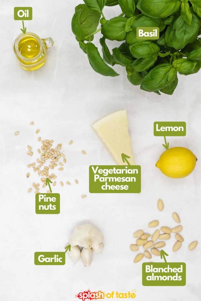 Ingredients needed to make homemade basil pesto, extra virgin olive oil, fresh basil, lemon for lemon juice, blanched almonds, garlic cloves & pine nuts.