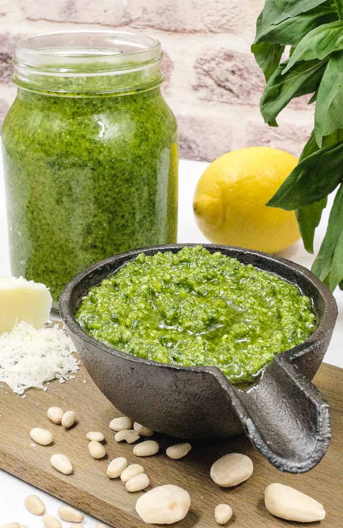 Homemade basil pesto in a mortar on a board.
