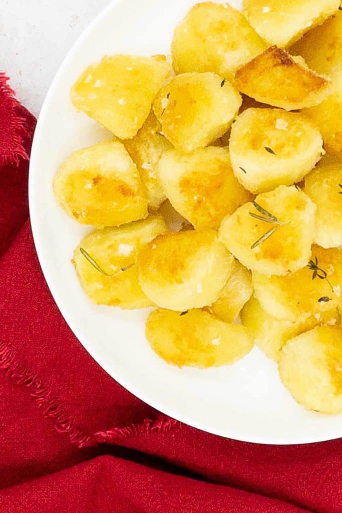 A bowl of crispy, golden brown oven roasted potatoes ready to eat.