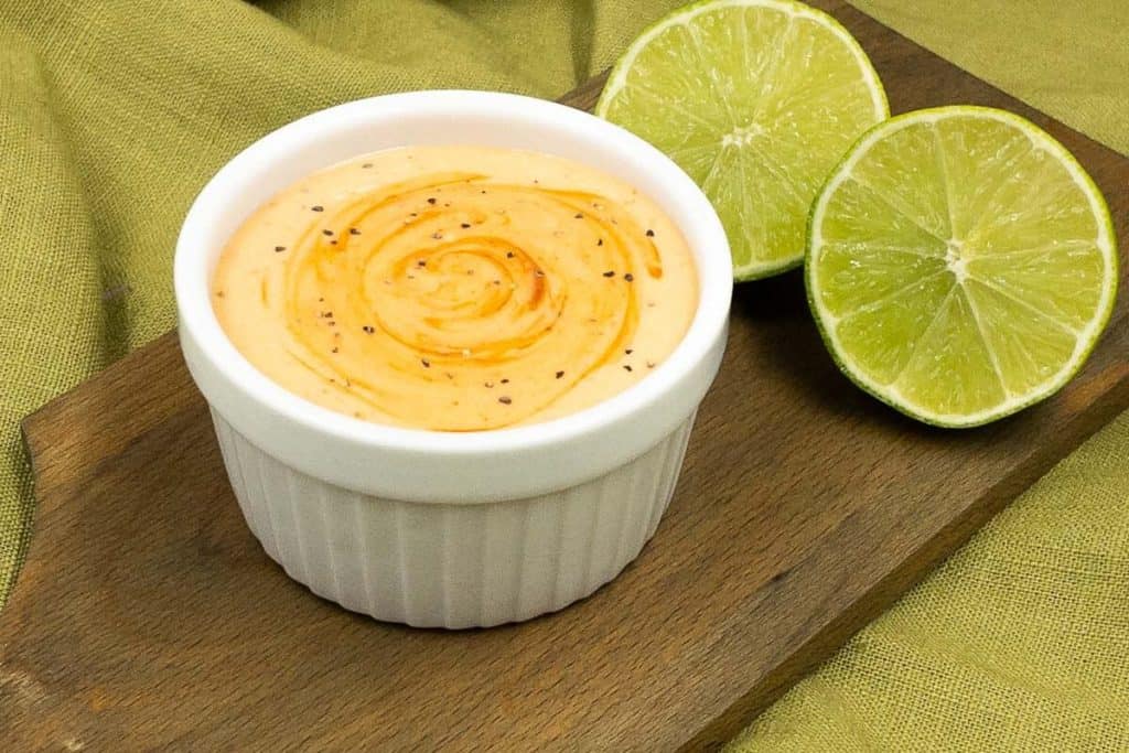 Freshly made sriracha with mayo dipping sauce with fresh limes.