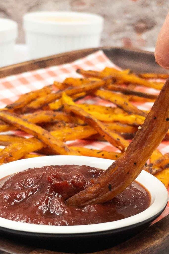 Dipping freshly made sweet potato fries in ketchup.