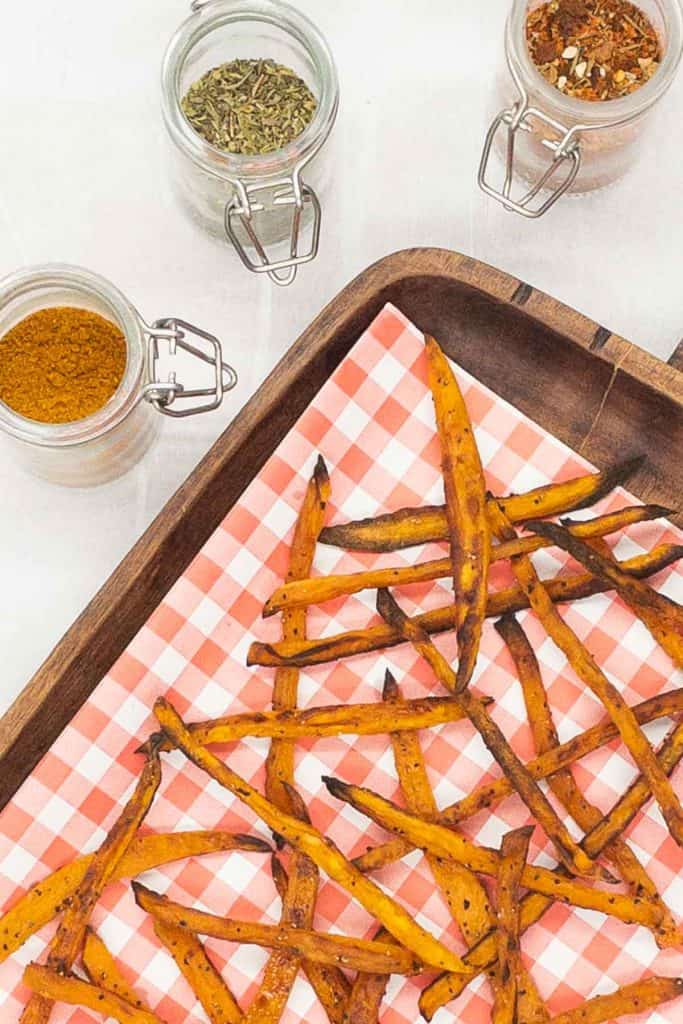 Sweet potato fries with jars of seasonings.