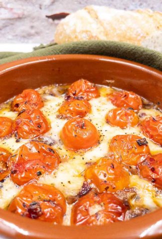 Tomato and baked goats cheese in an ovenproof dish.