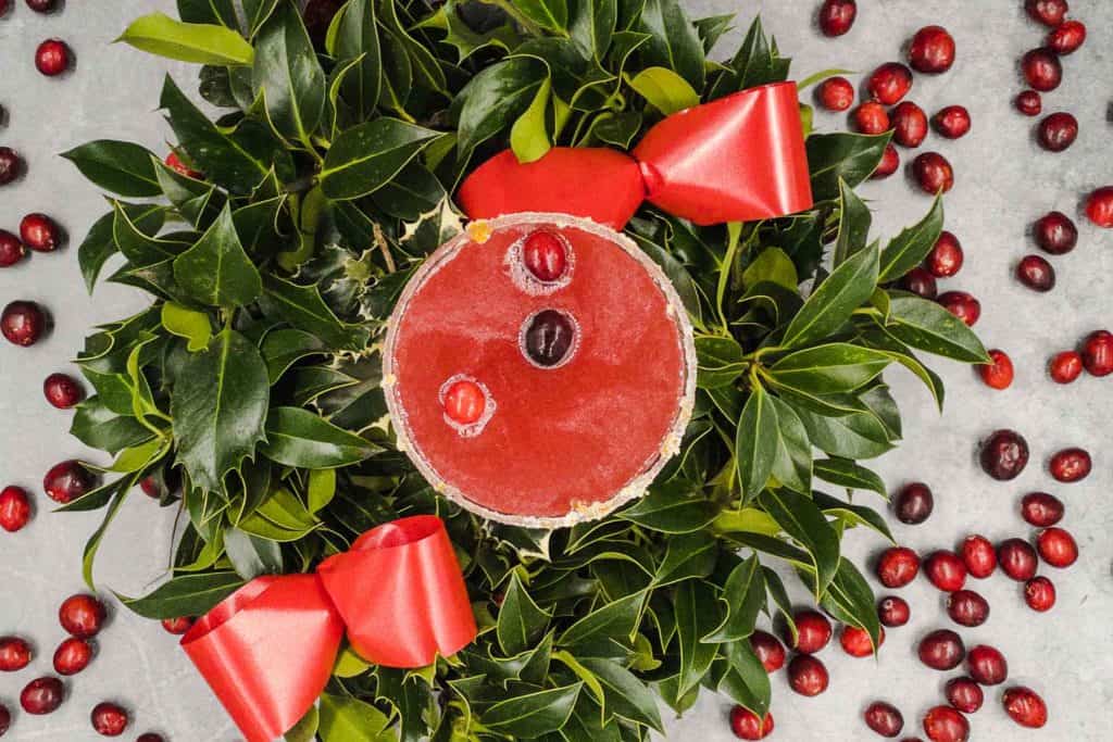 Overhead shot of a festive margarita with cranberries.