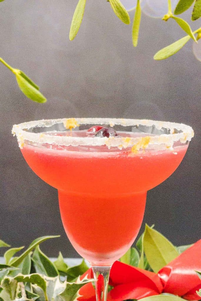 Festive Cranberry margarita cocktail with mistletoe and holly.