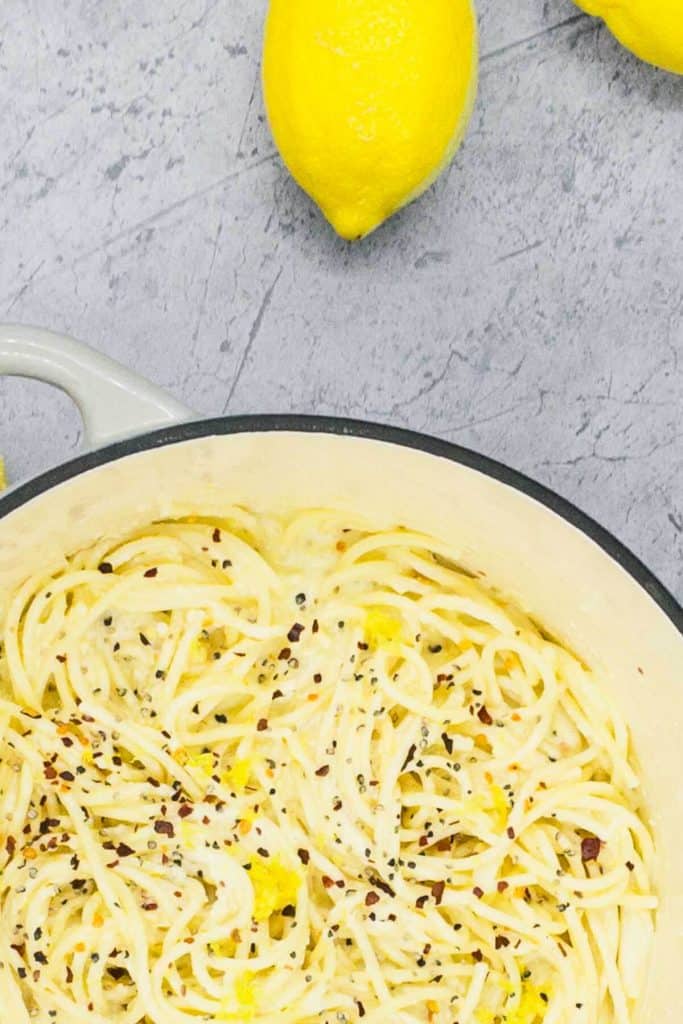 A pot of freshly made lemon pasta with red pepper flakes, salt and pepper.