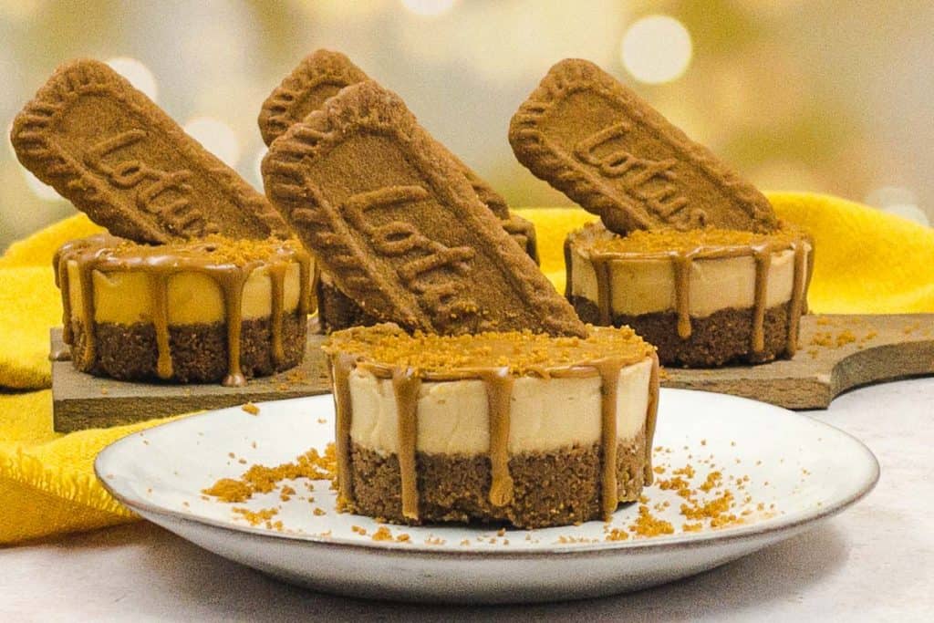 Tasty single portion Biscoff  cheesecake made with Boscoff with a Biscoff biscuit coming out of each cheesecake