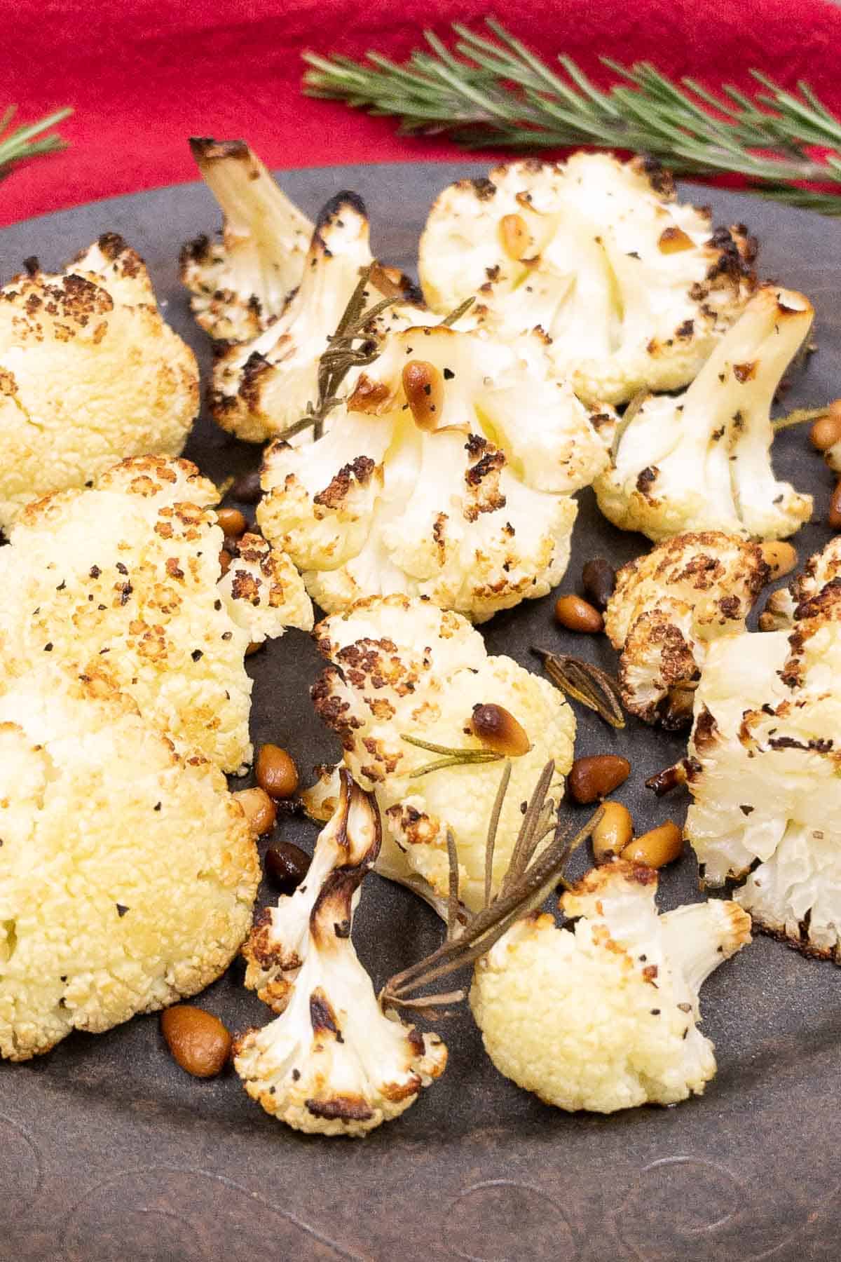 A dish of delicious roasted cauliflower with rosemary and pine nuts.
