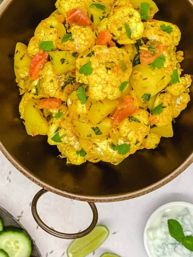 A delicious bowl of homemade gobi aloo, with coriander leaves sprinkled on top.