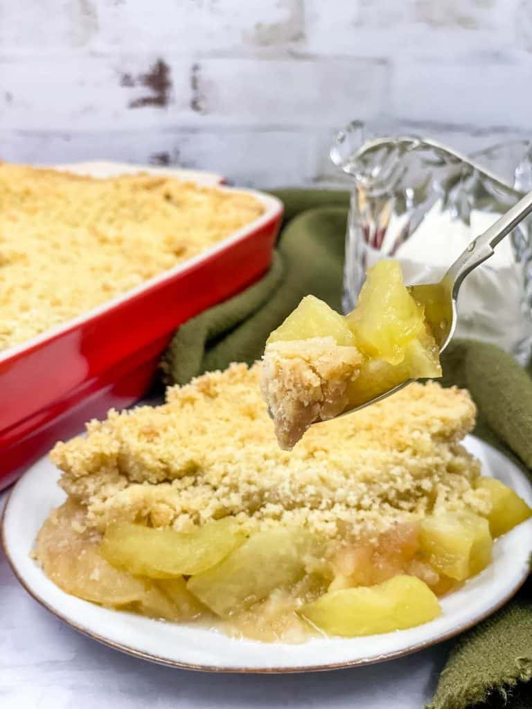 A fork full of homemade apple crumble taken from a dish.