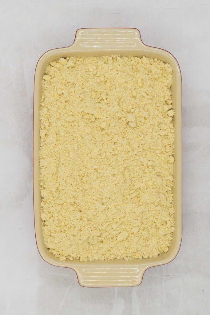 A baking dish with an unbaked apple crumble.