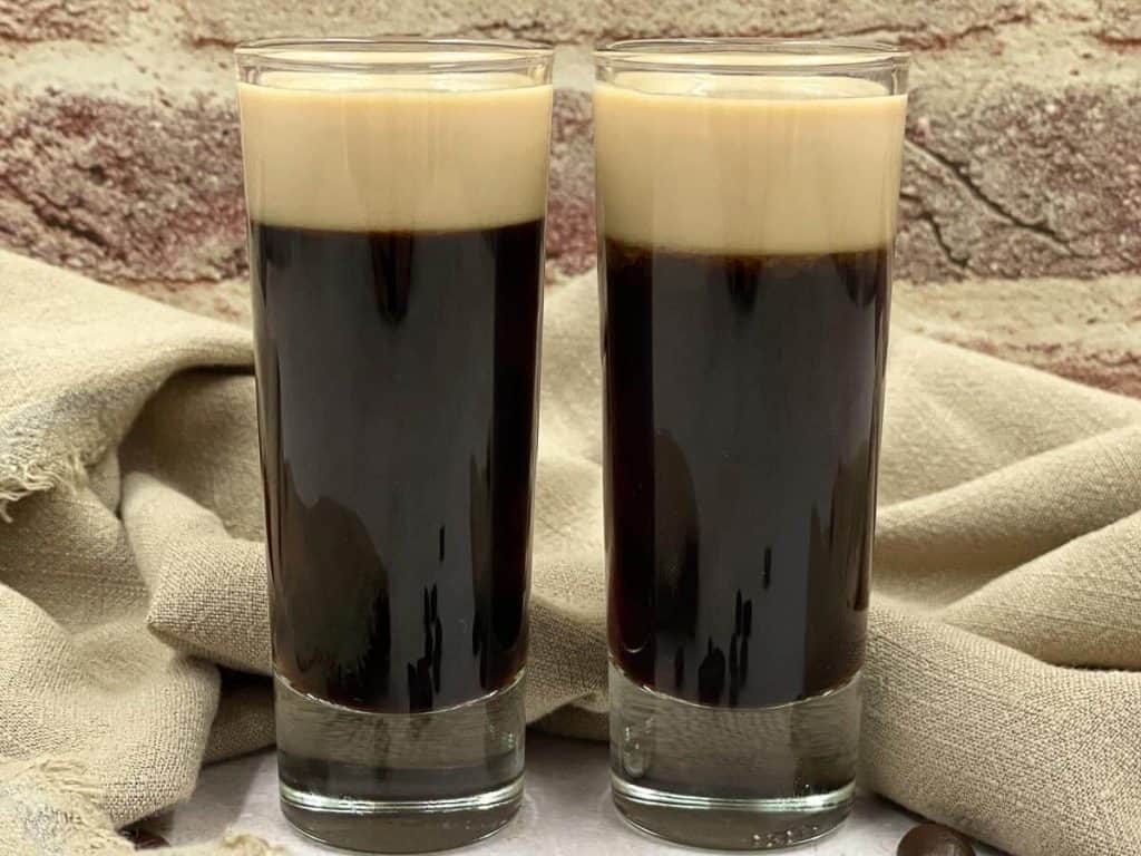 Two tiny baby Guinness shots ready to drink.