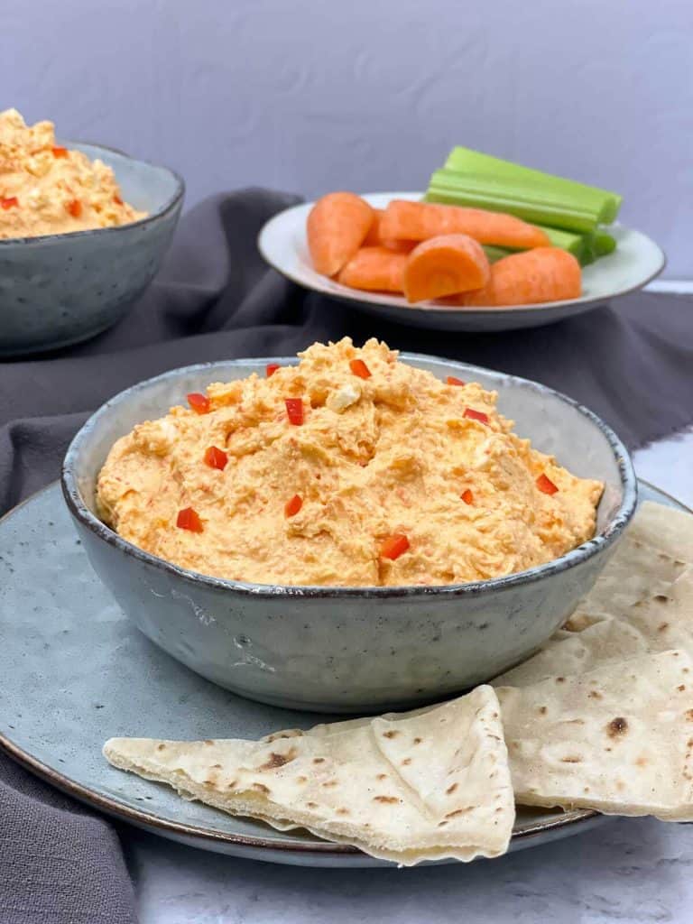 A delicious bowl of spicy Greek feta dip tirokafteri, with pita bread, carrots and celery.