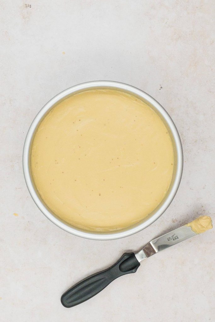 Spread the cheesecake filling evenly over the biscuit base.