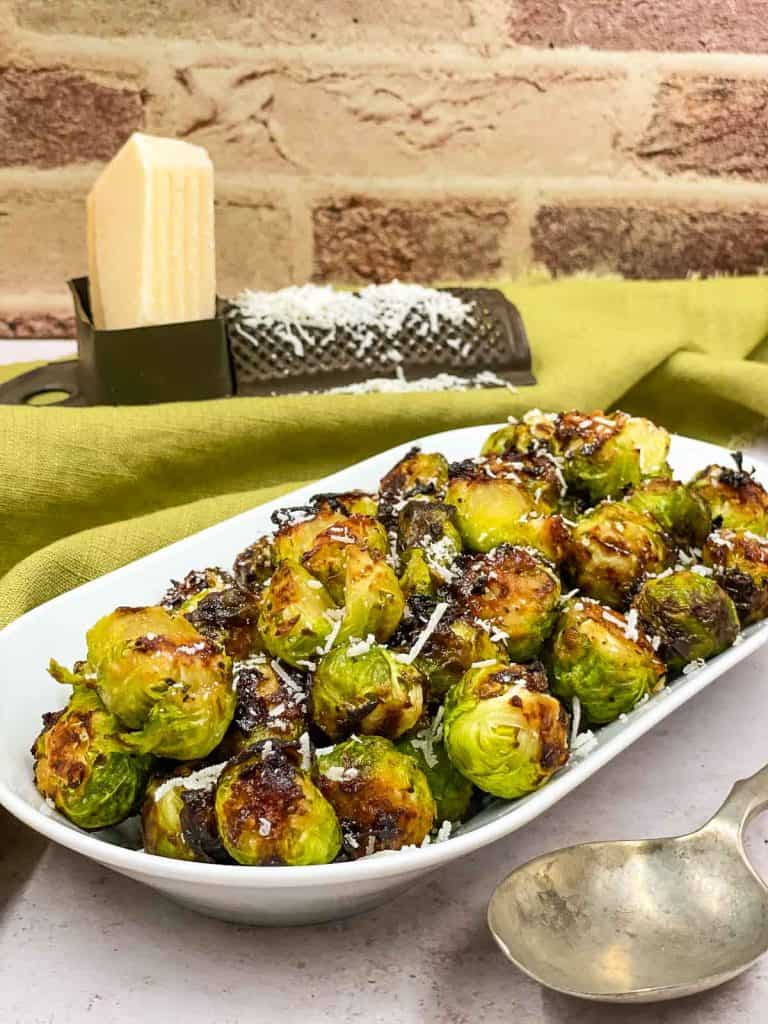 Air fryer Brussel sprouts jut cooked, with Parmesan cheese on top.