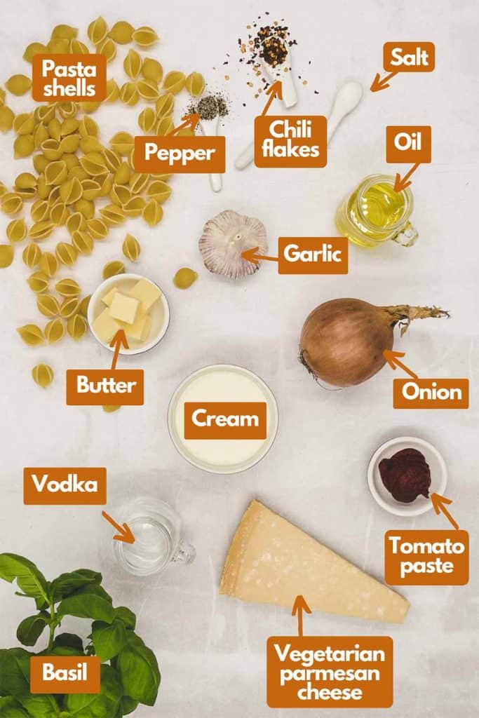 Ingredients needed, shell pasta, black pepper, red chilli flakes, salt, extra virgin olive oil, onion, garlic, heavy cream, butter, tomato paste, vegetarian Parmesan cheese, vodka, & fresh basil.