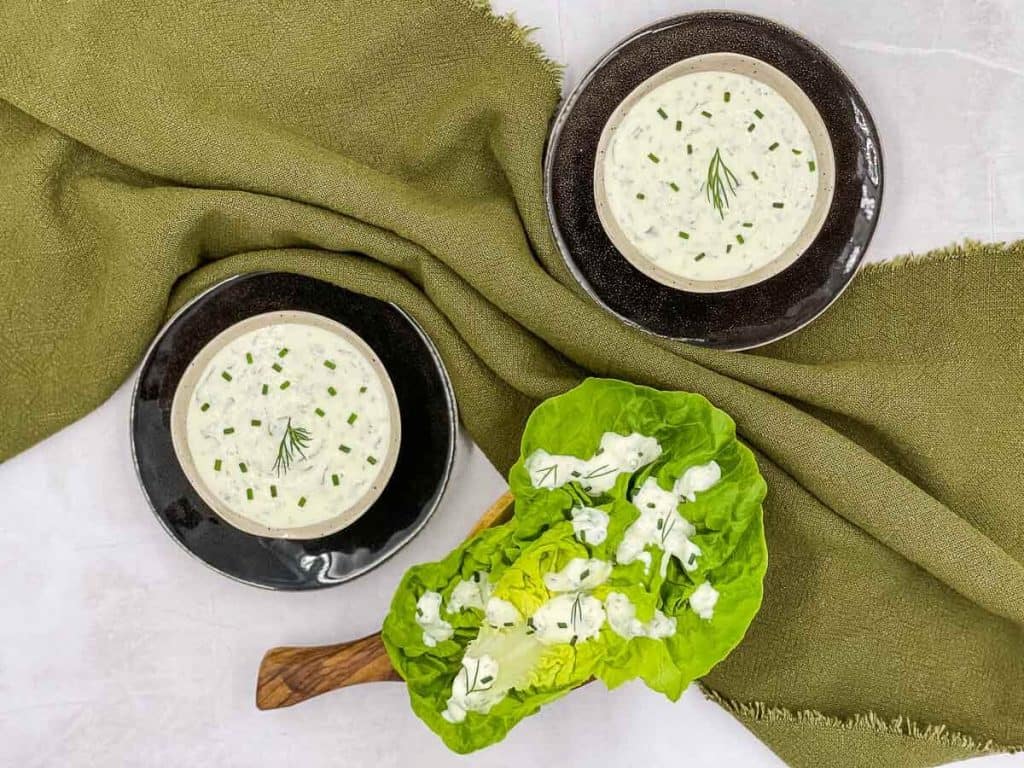 Homemade buttermilk ranch dressing in two bowls and drizzled over lettuce.